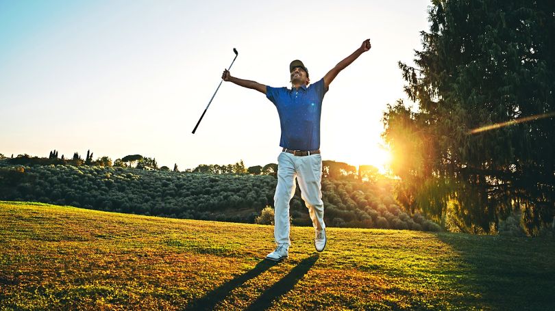 Un golfeur se réjouit après un trou d’un coup sous un soleil radieux.
