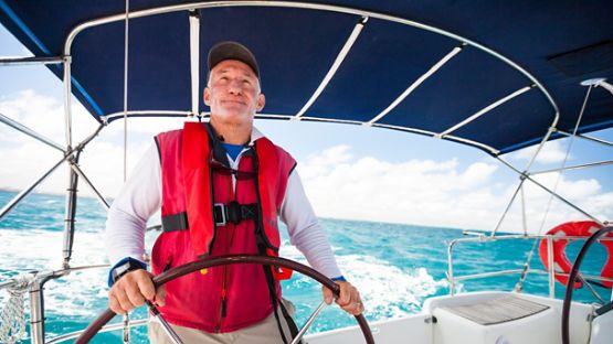 A tight shot of a person at the wheel of a contemporary cabin cruiser