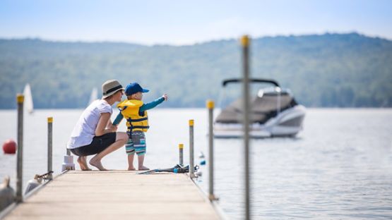 A young boy and his mother enjoying the lake view at the end of the dock 
