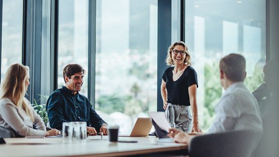 Des employés tiennent une discussion informelle dans une salle de réunion.