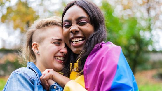 Deux femmes célèbrent ensemble la Fierté lors d’un festival.